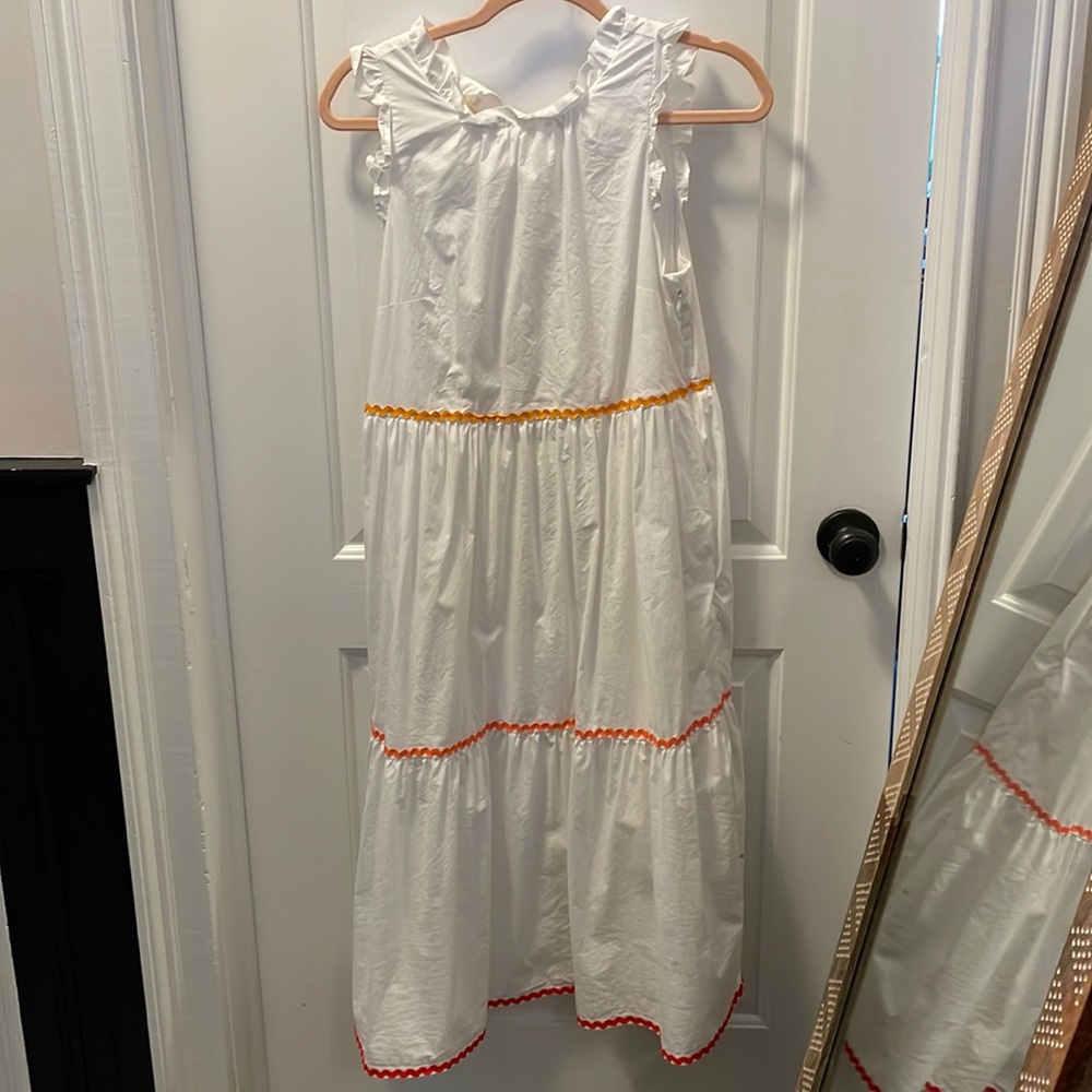 White dress with orange details.